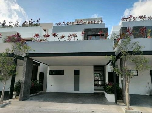 Fachada de casa RODOM con cochera doble y jardineras